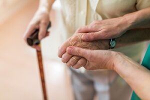 Ombudsman consoling an older patient by holding her hands